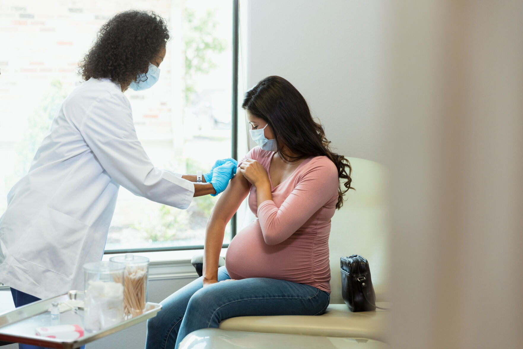 Pregnant woman receives vaccine at doctor's office